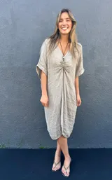 Vestido de lino color beige, con escote en V, mangas cortas y corte holgado.