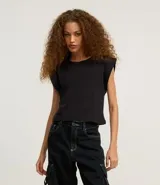 Blusa sin mangas, color blanco, confeccionada en tejido rib de algodón, con cuello redondo y hombreras marcadas.