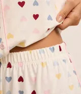Pijama americano corto de viscosa con estampa de corazones, compuesto por una camisa de manga corta con cuello inglés y cierre de botones, y un short con cintura elástica.