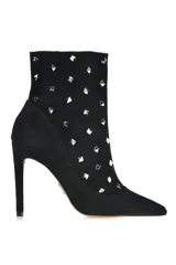 Bota de cuero negro con tachas metálicas decorativas y tacón alto.