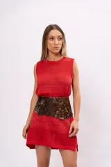 Vestido corto de tejido de punto calado color rojo, sin mangas y con cuello redondo.