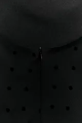 Vestido largo negro con lunares, cuello halter y escote pico.