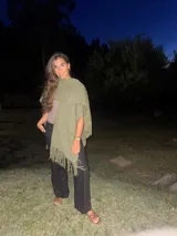 Ruana de tejido grueso color verde seco, con flecos largos en los bordes.