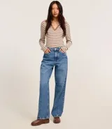 Blusa de punto con rayas horizontales marrones y blancas, cuello polo con escote en V y mangas largas.