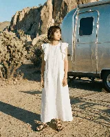 Vestido largo blanco de lino con bolsillos delanteros y volados en los hombros.