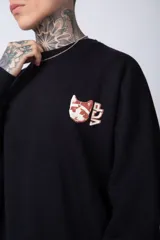 Buzo color crema de corte oversize confeccionado en tela friza con cuello redondo y puños y cintura acanalados. Presenta un pequeño bordado en el frente y un estampado grande en la espalda.