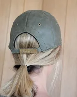 Gorra tipo béisbol color marrón, confeccionada en cuero gamuzado.