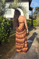 Vestido strapless largo con estampado batik en tonos marrones y beige, entallado al cuerpo y con espalda baja descubierta.