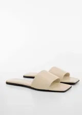 Sandalias bajas color beige con punta cuadrada, destalonadas y con abertura en la parte delantera.