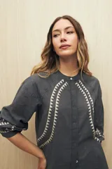 Camisa gris oscuro con estampado de triángulos blancos en el frente, mangas y cuello.