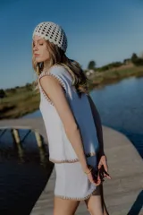 Conjunto tejido de algodón color celeste con terminaciones en marrón. Incluye un top sin mangas con botones y un short de tiro alto.