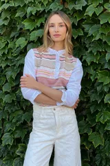 Blusa rosada con mangas largas, cuello con volados y estampado de líneas verticales.