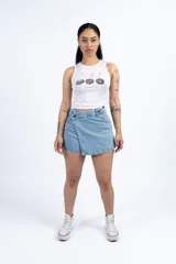 Short pollera de jean celeste con diseño cruzado y cierre con botón.