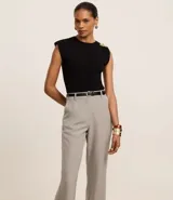 Pantalón de vestir gris claro, de corte recto, con bolsillos laterales y traseros. Se ajusta a la cintura con cinturón de cuero negro.