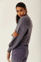 Cárdigan color marrón con tejido de punto acanalado, escote en V, cierre frontal con botones y mangas largas abullonadas.