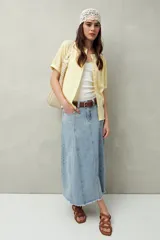 Falda midi de denim negro con tiro bajo, corte evasé, costuras verticales y ruedo desflecado.