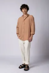 Camisa blanca de lino con cuello clásico, manga larga con puños abotonados y corte holgado. 