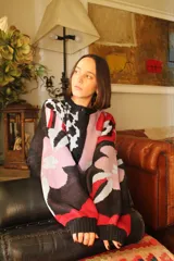 Cárdigan de punto con estampado floral en tonos celeste, verde, marrón y violeta. Tiene corte oversized y cierre frontal con botones.