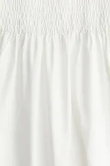 Vestido midi blanco con cuerpo entallado fruncido, escote redondo y breteles spaghetti. Costura fruncida en la cintura y pollera con leve vuelo.