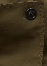 Trench coat verde militar con cuello solapa ancho, doble botonadura, cinturón desmontable, trabillas en cintura y puños, dos bolsillos laterales y forro interior.