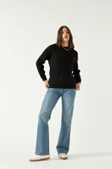 Sweater negro de punto suave con cuello redondo y hombros caídos.