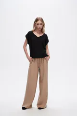 Pantalón negro ancho de viscosa con vivos laterales en blanco, dorado y marrón.