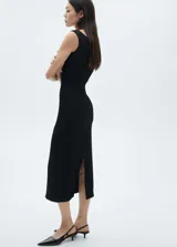 Vestido midi negro de tejido texturizado, con cuello barco y sin mangas.