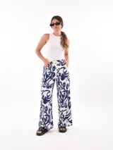 Pantalón palazzo con estampado de hojas y flores en tonos azul y blanco.