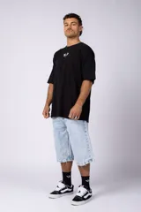 Remera negra oversize de mangas cortas con estampado pequeño de dos caballos blancos en el pecho.