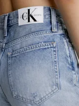 Pantalón de jean celeste claro, de corte mom, con roturas en las rodillas y ruedo desflecado.