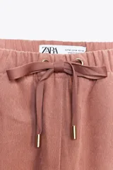 Pantalón de tiro alto color ladrillo, con cintura elástica ajustable, bolsillos delanteros y traseros. Corte ancho.