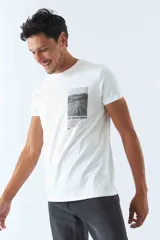 Remera blanca de algodón con cuello redondo y estampado rectangular con imagen de una carretera y texto en el frente.
