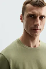 Camiseta verde oliva de punto, corte recto, con cuello redondo y mangas cortas.