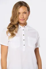 Camisa color beige de lino y algodón, de manga corta, con cuello clásico, medio abotonado y dos bolsillos en el pecho.