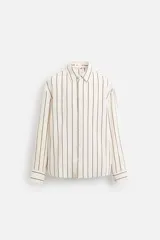 Camisa de hombre regular fit, color blanco con rayas verticales negras, cuello solapa, manga larga con puños abotonados y cierre frontal con botones.