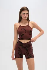 Top marrón con estampado abstracto negro, breteles finos y cuello redondo.