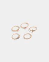 Set de cinco anillos dorados con detalles en relieve y strass multicolor.