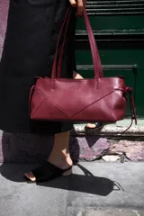 Cartera de cuero color bordó, con forma alargada, cierre metálico color níquel, bolsillo interno con cierre e interior 100% algodón.