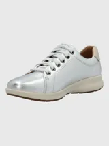 Zapatilla urbana de cuero color dorado, con cordones y suela blanca.
