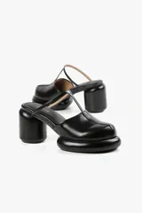 Mule color caramelo con plataforma y taco cilíndrico, tira superior negra y puntera cuadrada.