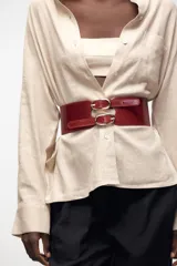 Cinturón tipo fajín color rojo de cuero, de 5 cm de ancho con doble hebilla ovalada dorada.