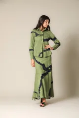 Camisa verde militar con estampado batik negro, de corte recto, manga larga y cuello camisero.