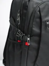 Mochila negra con detalles en rojo, con múltiples compartimentos y cierre con cremallera.