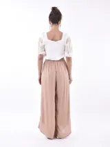 Pantalón palazzo lila con cintura elastizada y aberturas frontales.