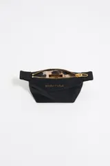 Monedero trapecio de tamaño mini, color crudo, con cierre dorado y logo de la marca estampado en dorado.