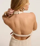 Vestido midi color crema con textura de malla, escote halter y espalda descubierta.