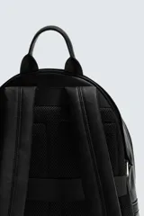 Mochila negra con acabado grabado, compartimento principal con cierre de cremallera, bolsillo frontal con cierre de cremallera, parte posterior acolchada con banda de sujeción para equipaje, asa de mano y dos asas de hombro ajustables.