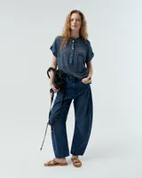 Remera celeste de lino y ramio, con corte boxy, manga japonesa, cuello mao, media cartera con broches metálicos y bolsillo plaqué con efecto de tapa.