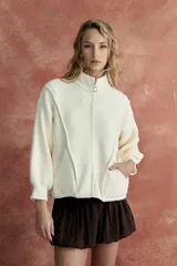 Saco de campera color blanco, con cierre frontal y diseño de mangas abullonadas.