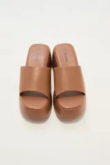 Sandalias negras con plataforma y tira ancha sobre el empeine.